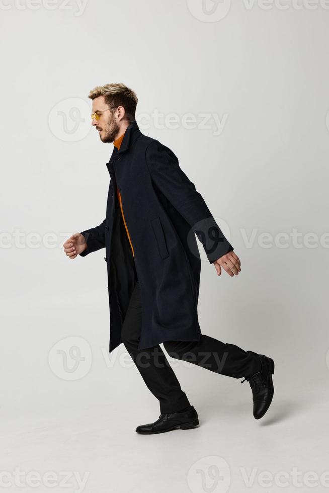 man fashionable glasses coat studio motion emotions photo