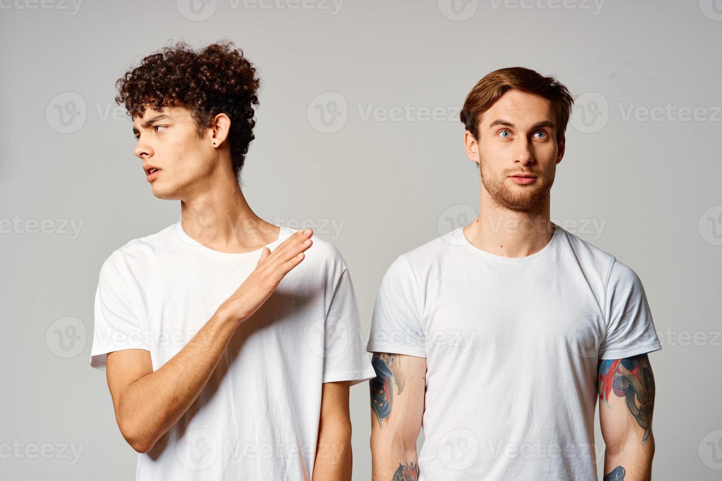two man in white t-shirts are standing next to friendship emotions photo