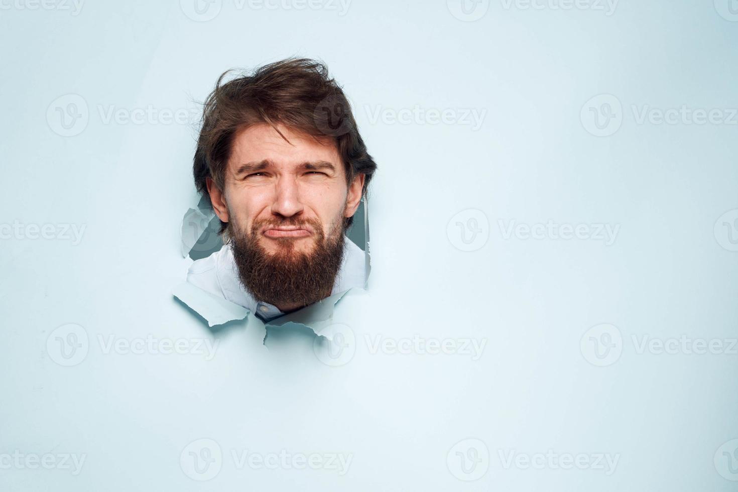 A disgruntled man looks out from behind the wall of the office manager's job photo