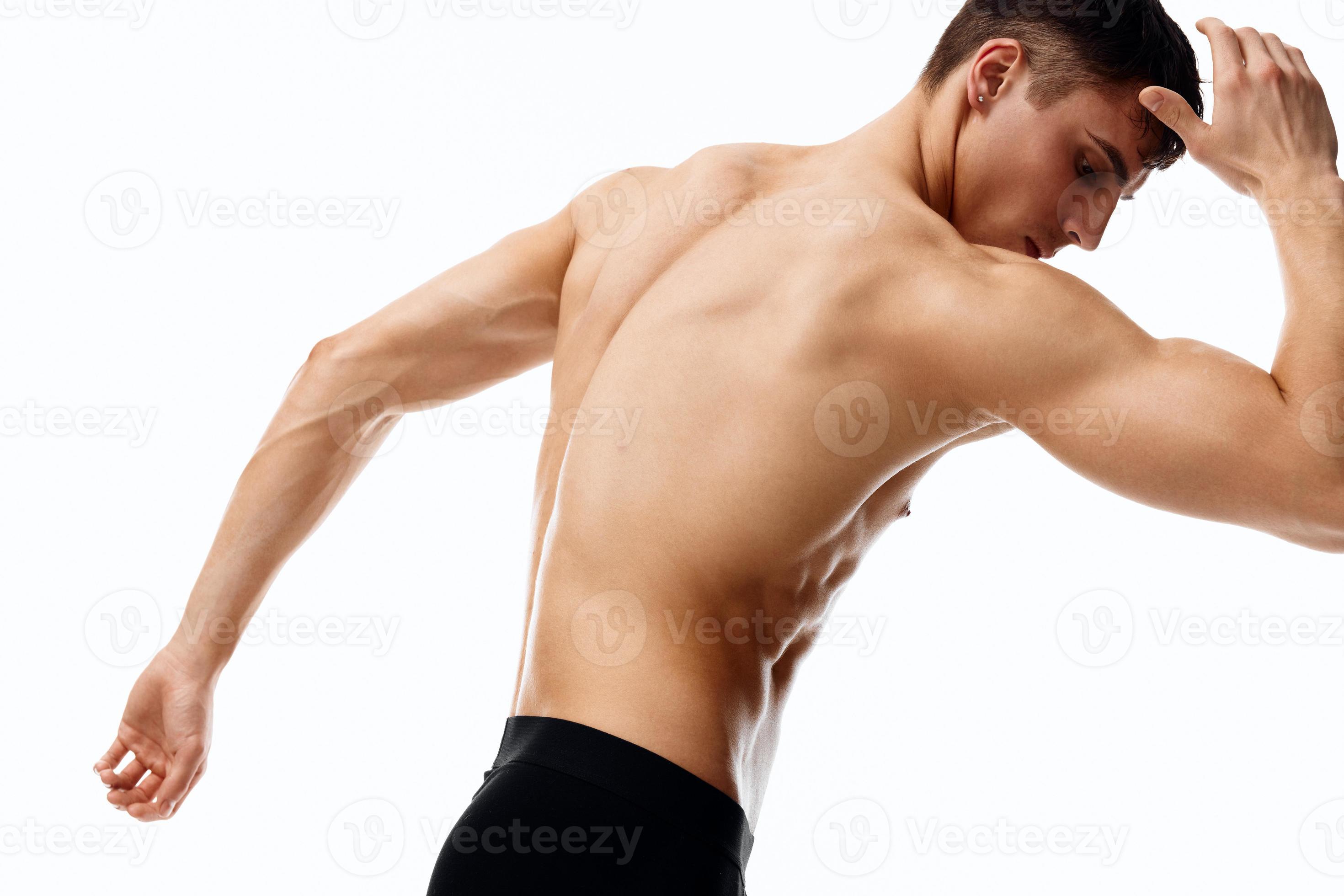 man in shorts and with his hands raised up bent to the side on a light  background cropped view 22066464 Stock Photo at Vecteezy