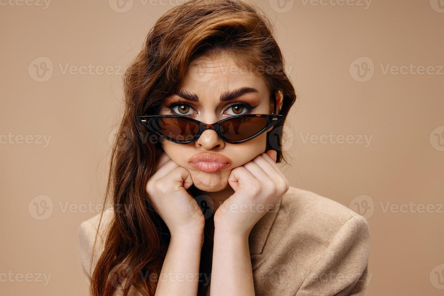portrait of a beautiful woman with glasses sad look and hands near the face hairstyle photo