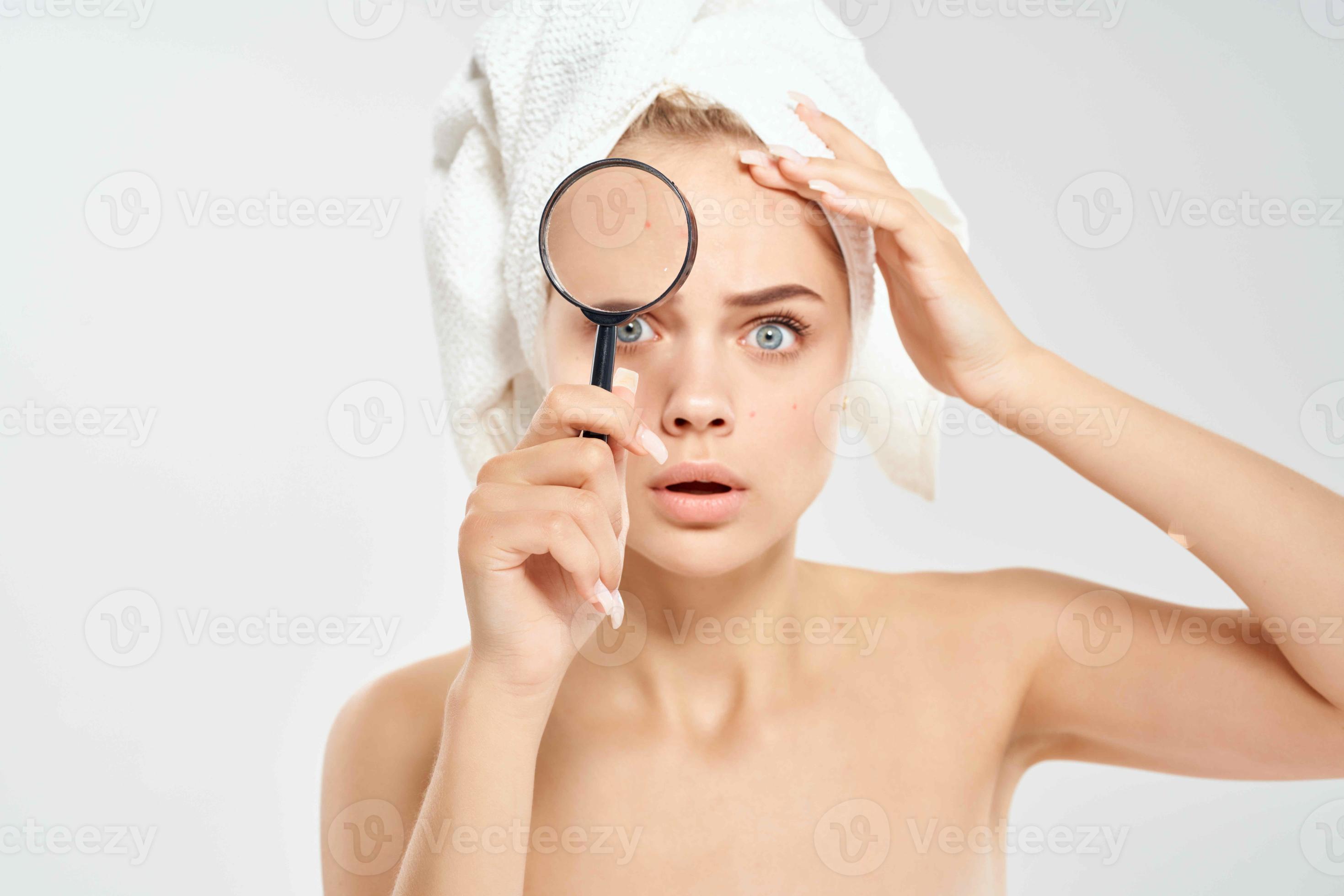 surprised woman with bare shoulders clean skin magnifying glass in