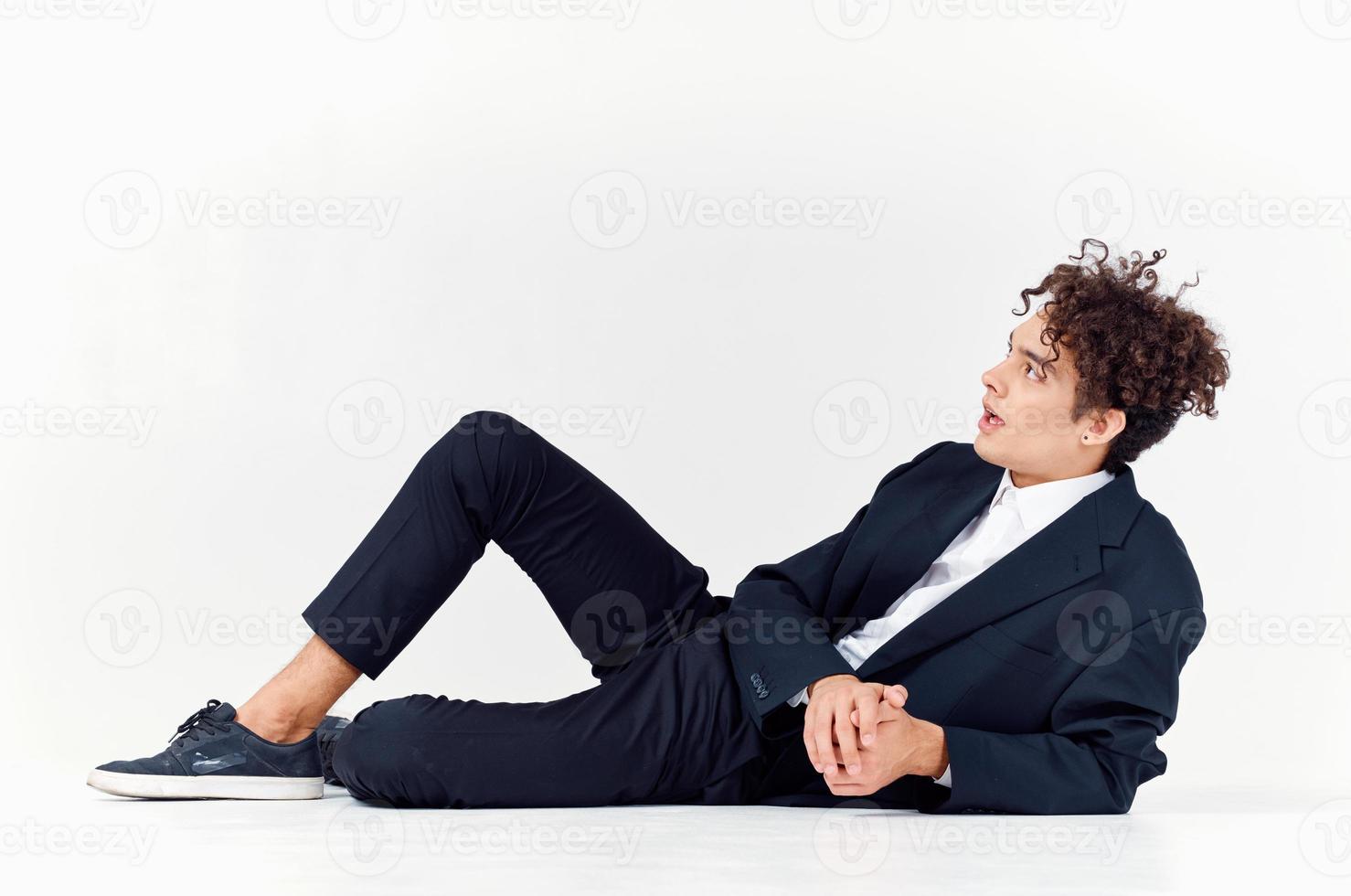 guy in trousers and a jacket lies on the floor In a bright room, photo