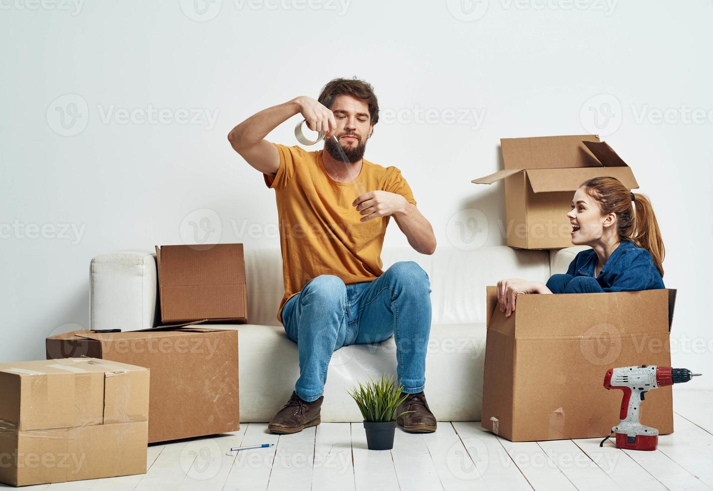 Man and woman boxes with things white sofa interior moving room photo