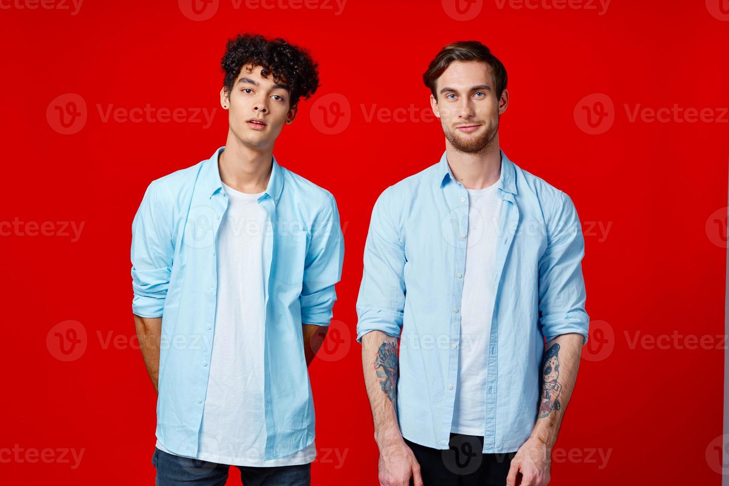 two men in shirts stand next to communication blue background photo