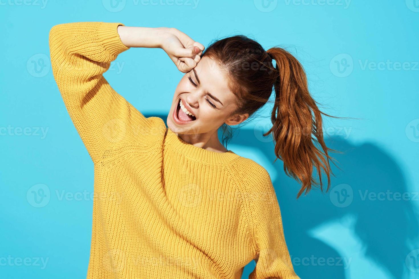 woman in yellow sweater fashion lifestyle cropped view blue background photo