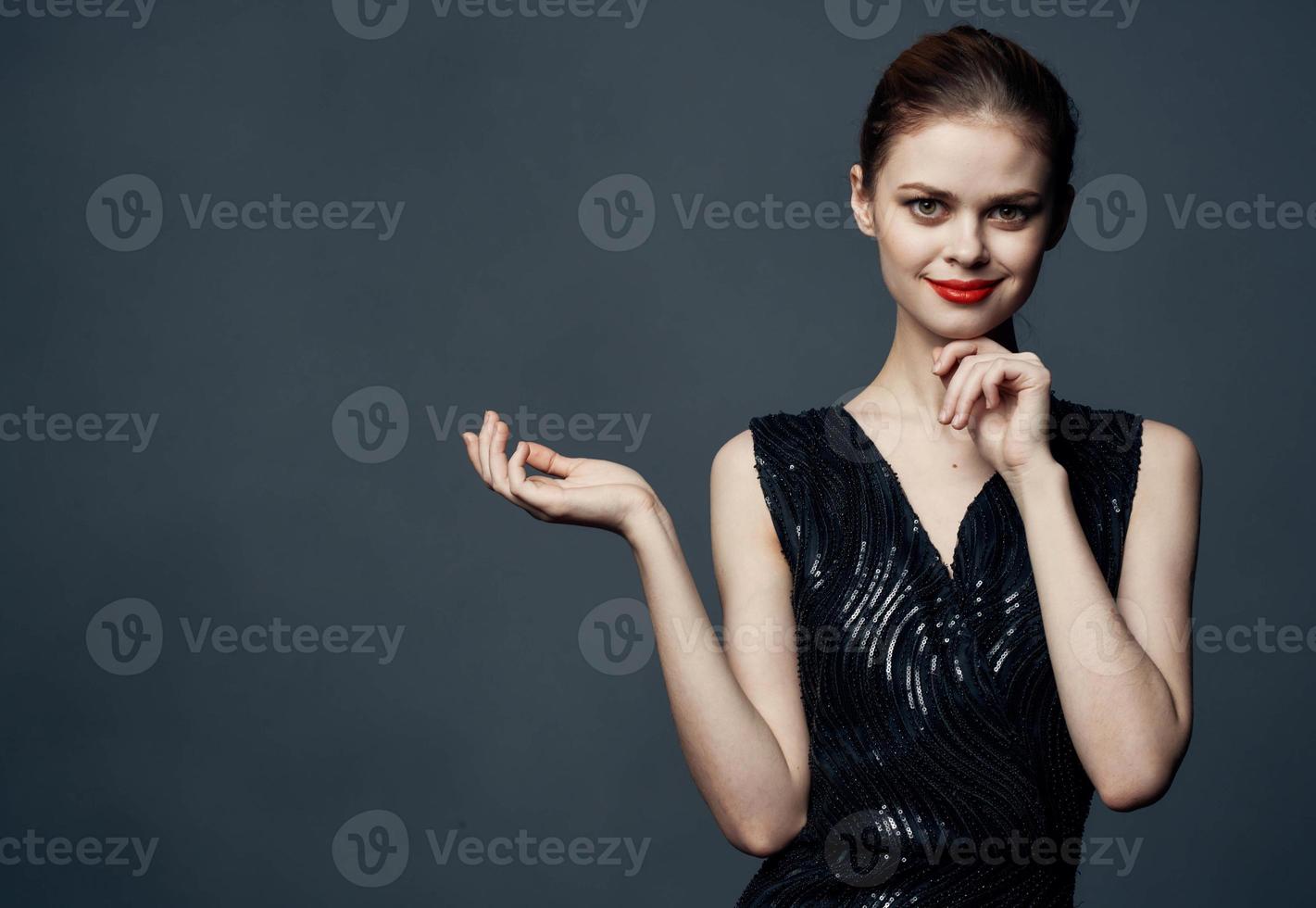 Woman shows her hands to the side on a gray background emotions advertising model photo