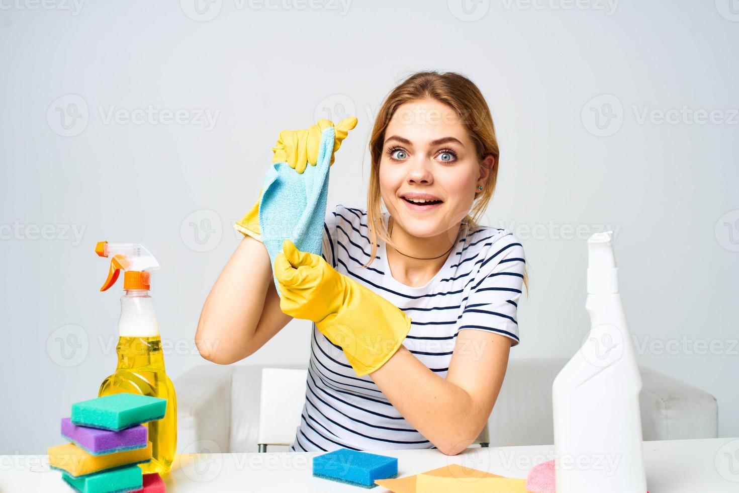 cleaning lady sitting at the table washing supplies work pallets light background photo