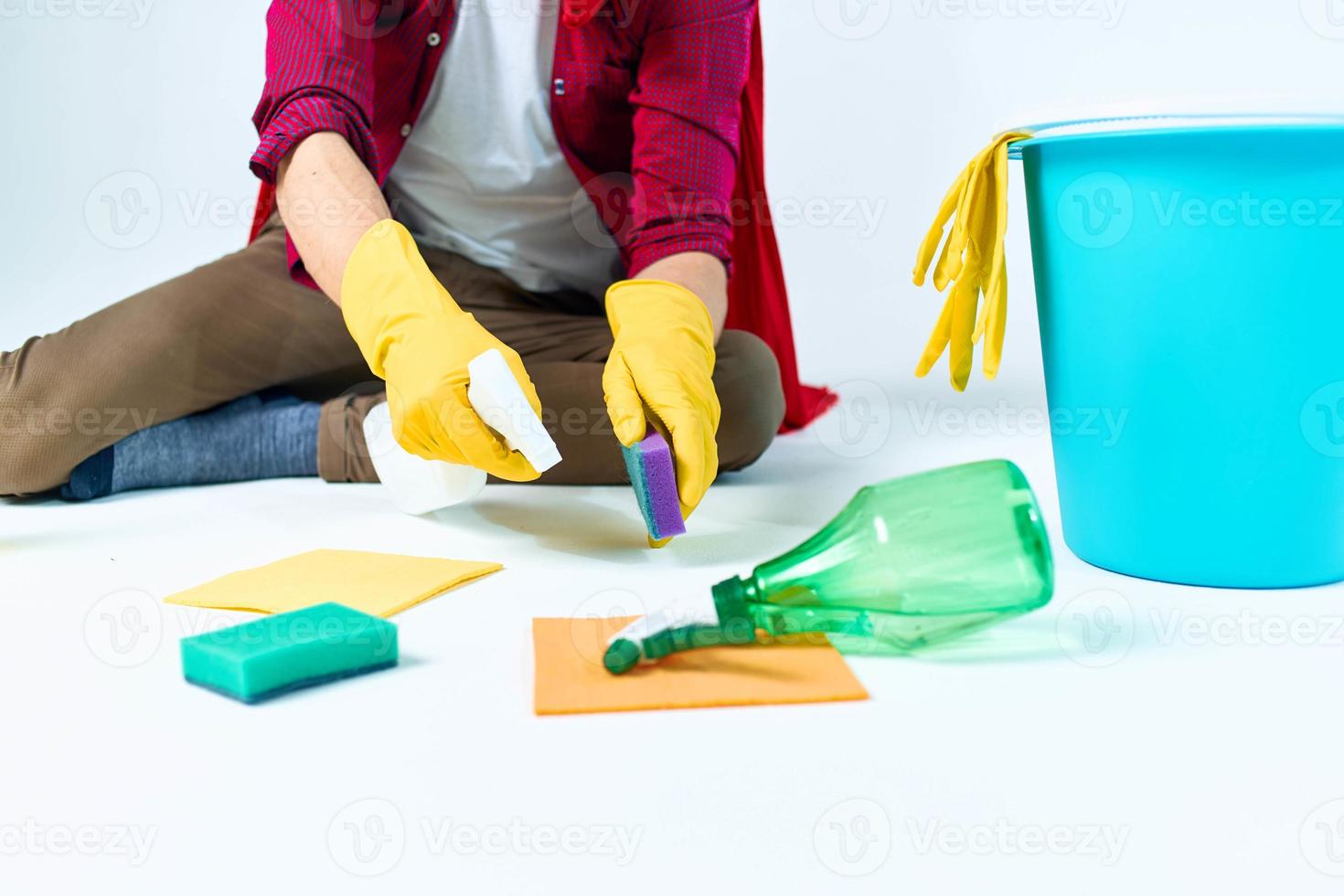 A man in a red raincoat sitting at home washing the floors providing services detergent accessories photo