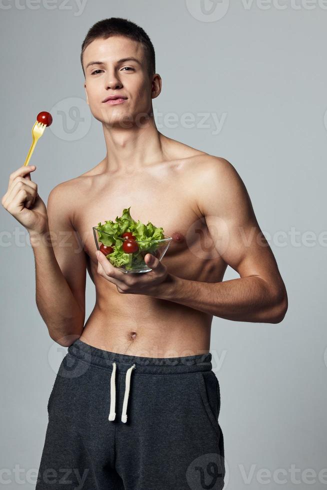 sports guy with pumped up abs plate light green meal isolated background photo