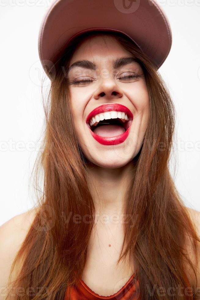 retrato de un mujer en un gorra sonrisa cerrado ojos encanto modelo foto