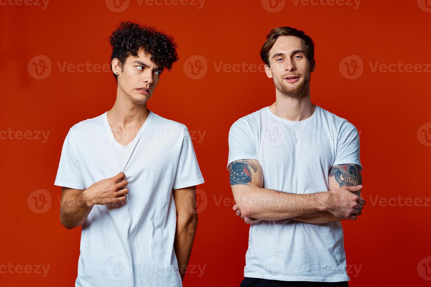 Two men in white t-shirts stand next to communication red background photo