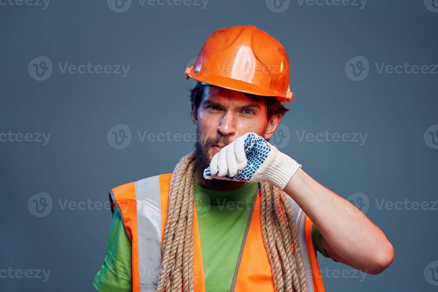 Man in orange paint glove professional construction blue background photo