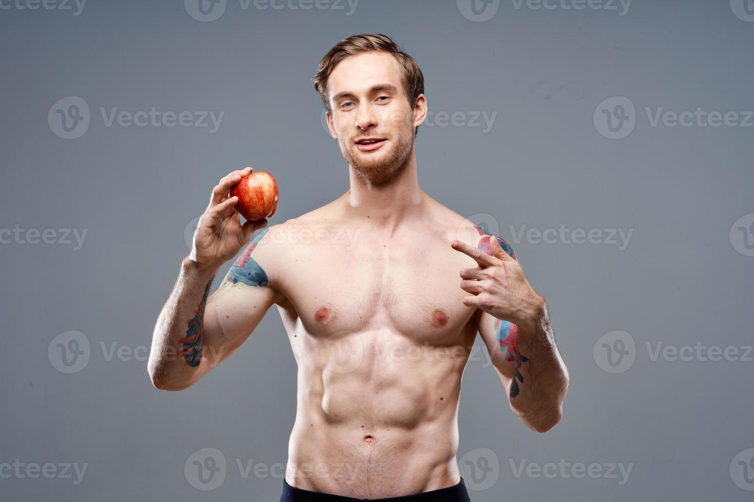 Man with apple and sport healthy food pumped up cake bodybuilder photo