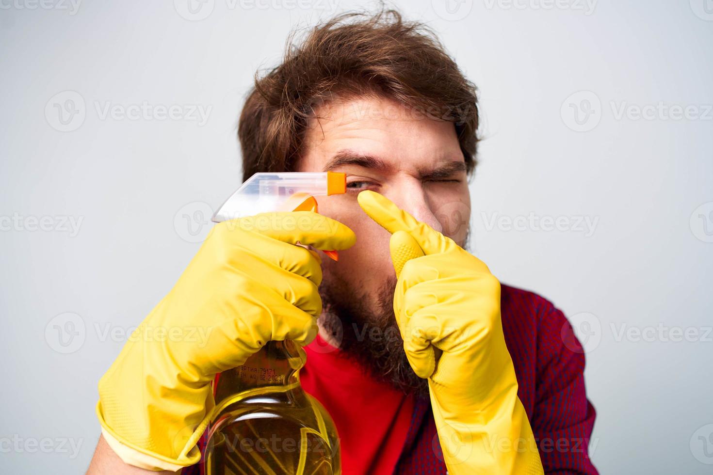 Man in yellow rubber gloves detergent housework rendering services close-up photo