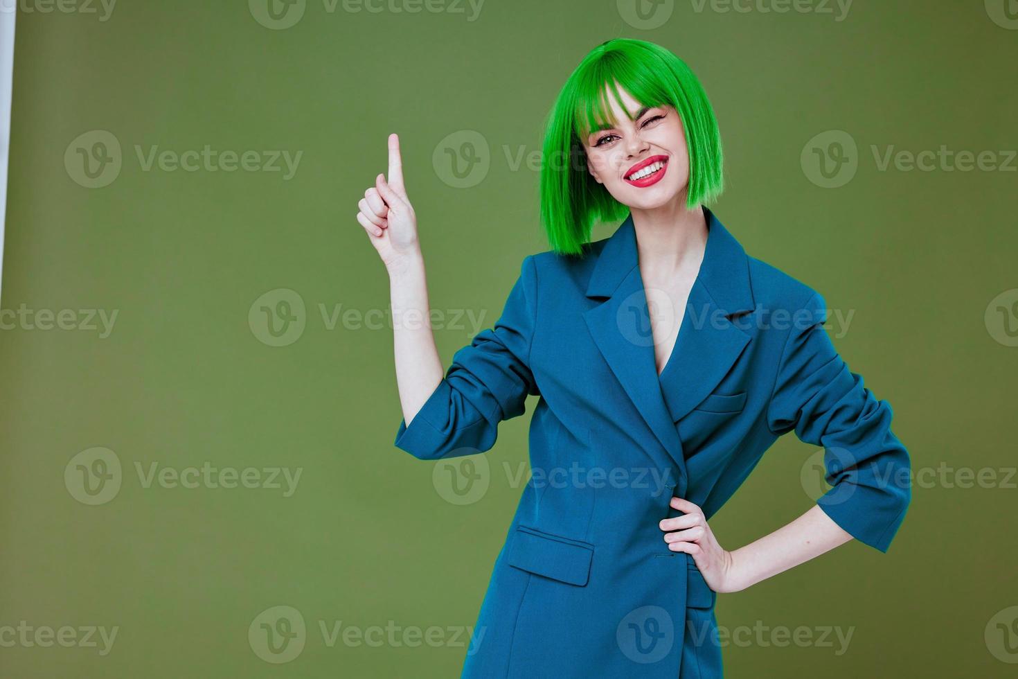Pretty young female wearing a green wig blue jacket posing color background unaltered photo