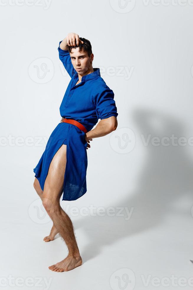 attractive man in a women's dress on a light background and a red belt at the waist model photo