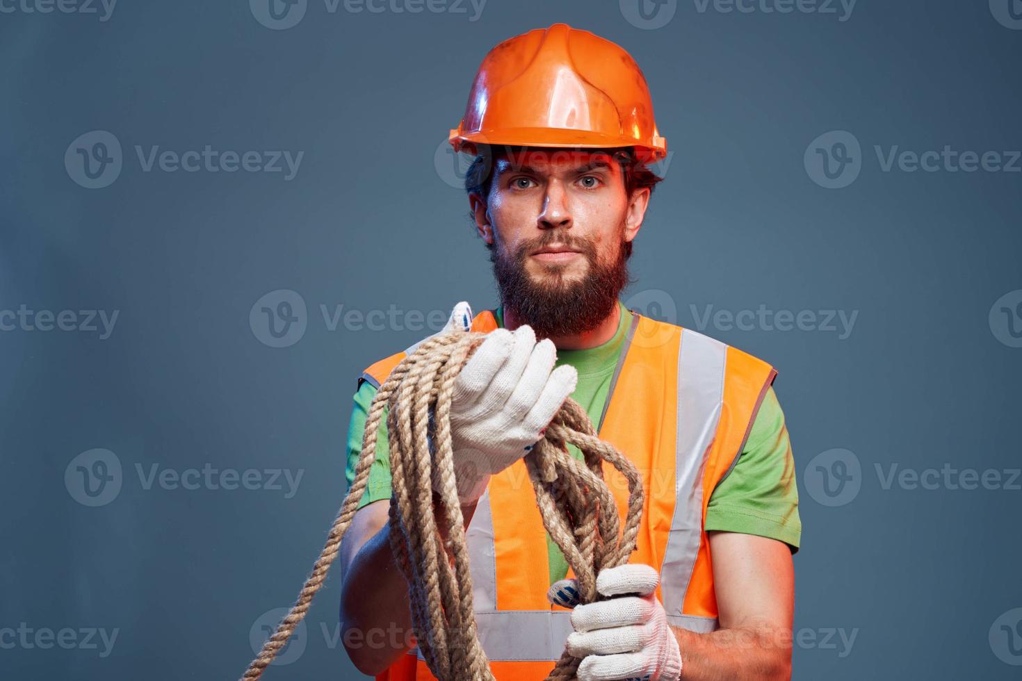 A working man in an orange paint rope in the hands of a construction professional photo