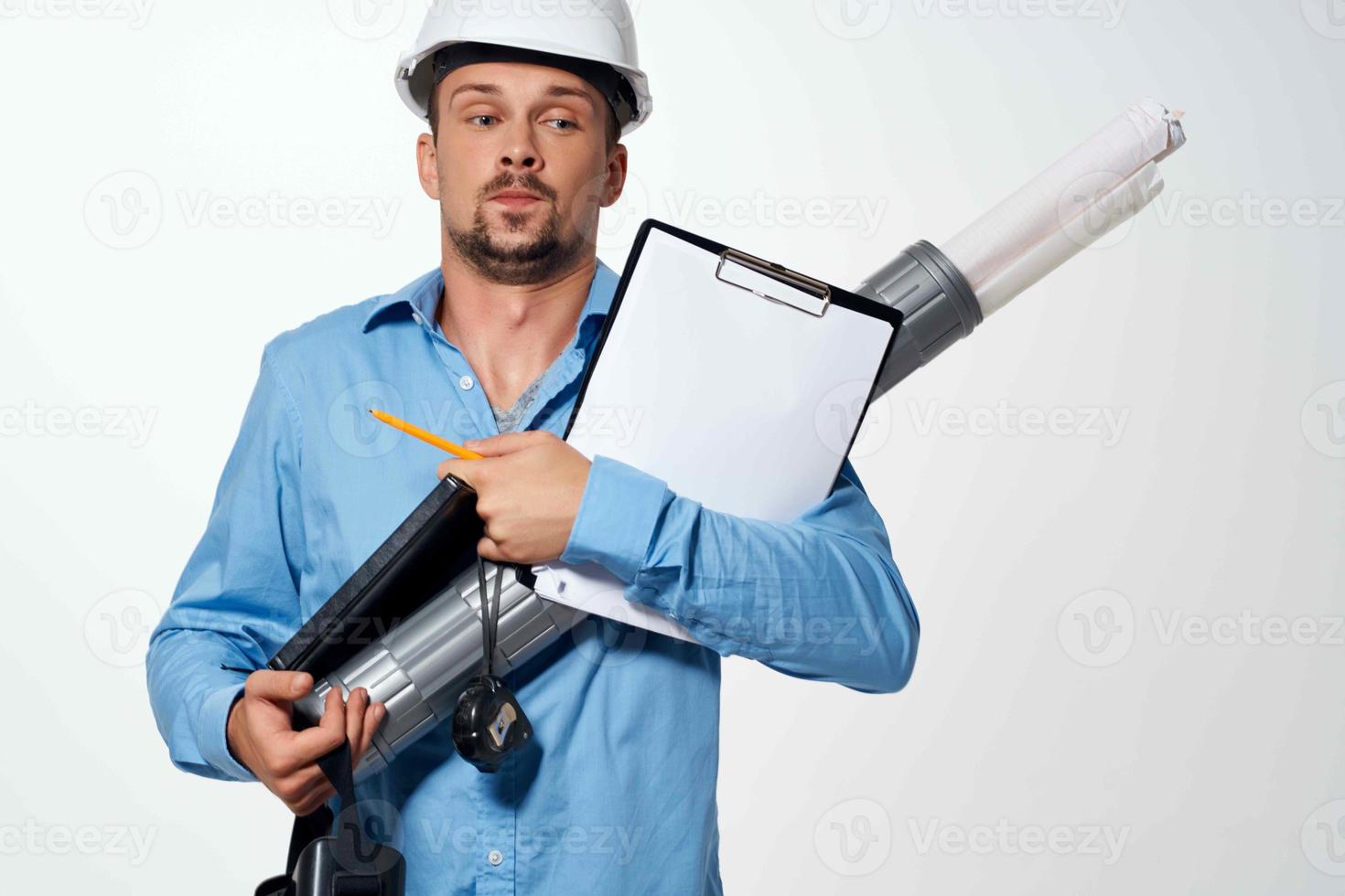 un hombre en un azul camisa en un construcción casco planos para construcción profesionales foto