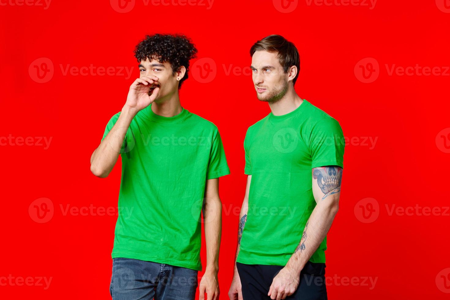 two friends in green t-shirts fun communication red background photo