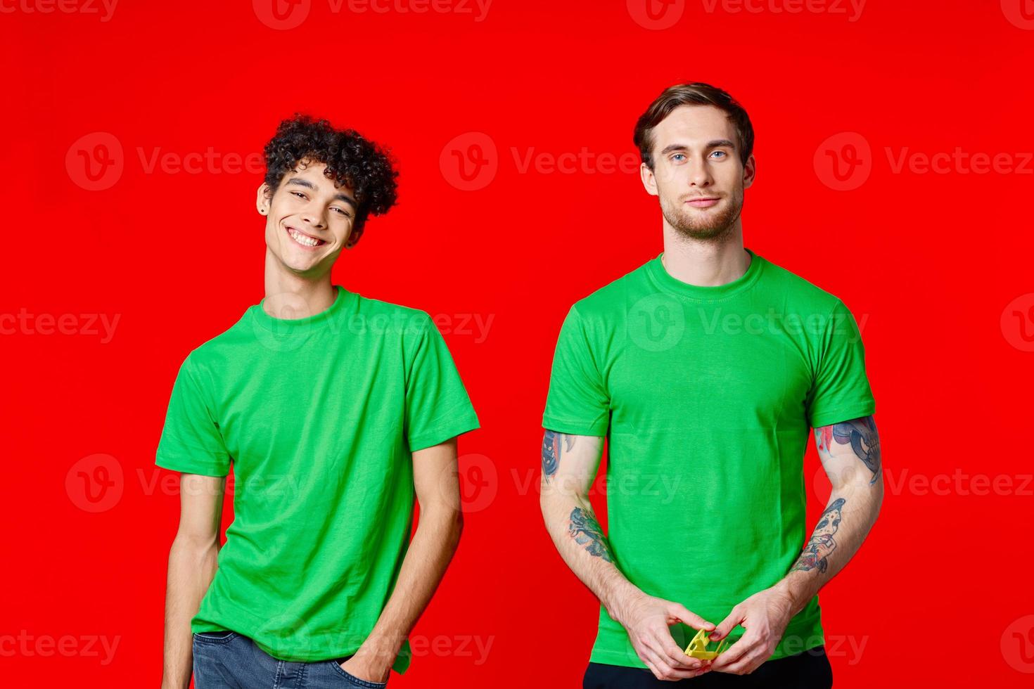 two friends are standing side by side in green T-shirts with glasses photo