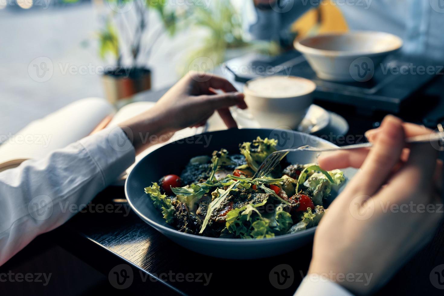 fresh salad in a plate delicious food diet fork in hand female hands cafe photo