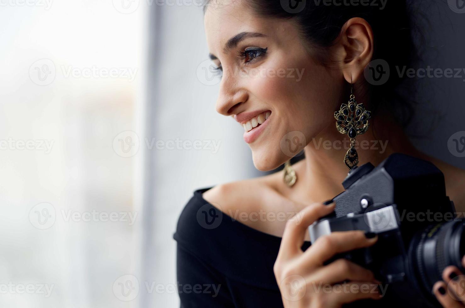 bonito mujer en un negro vestir cerca el ventana posando Moda modelo foto