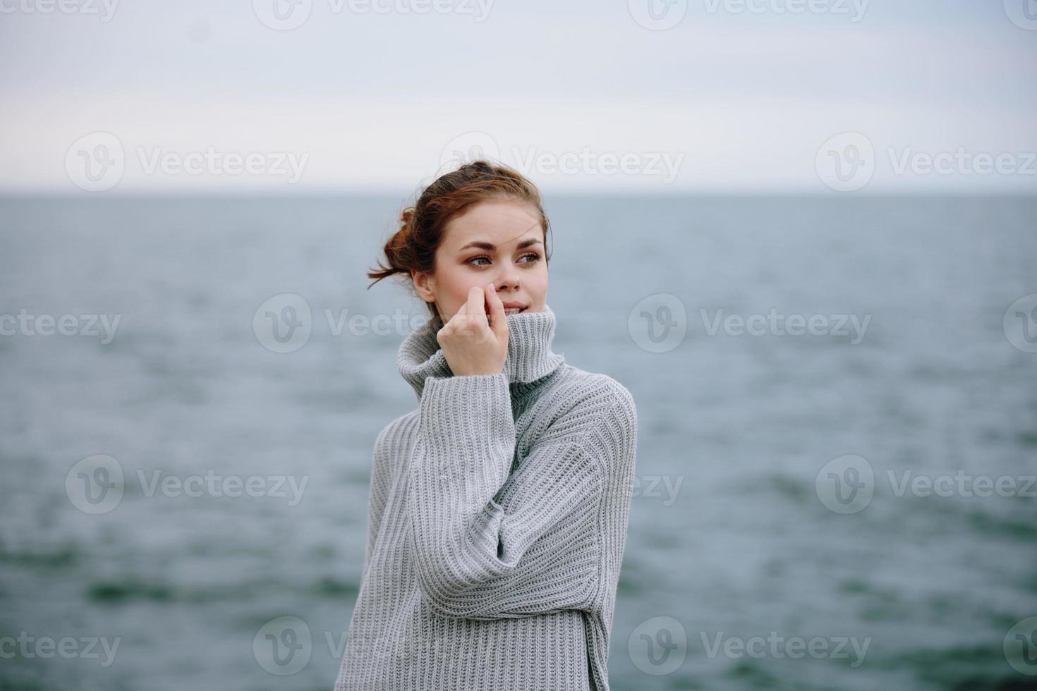 woman sweaters cloudy sea admiring nature Relaxation concept photo