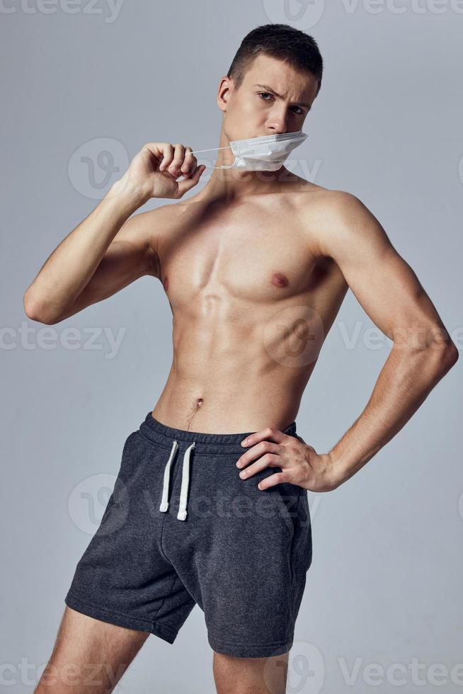 sports man with naked torso bodybuilder workout medical mask protection photo