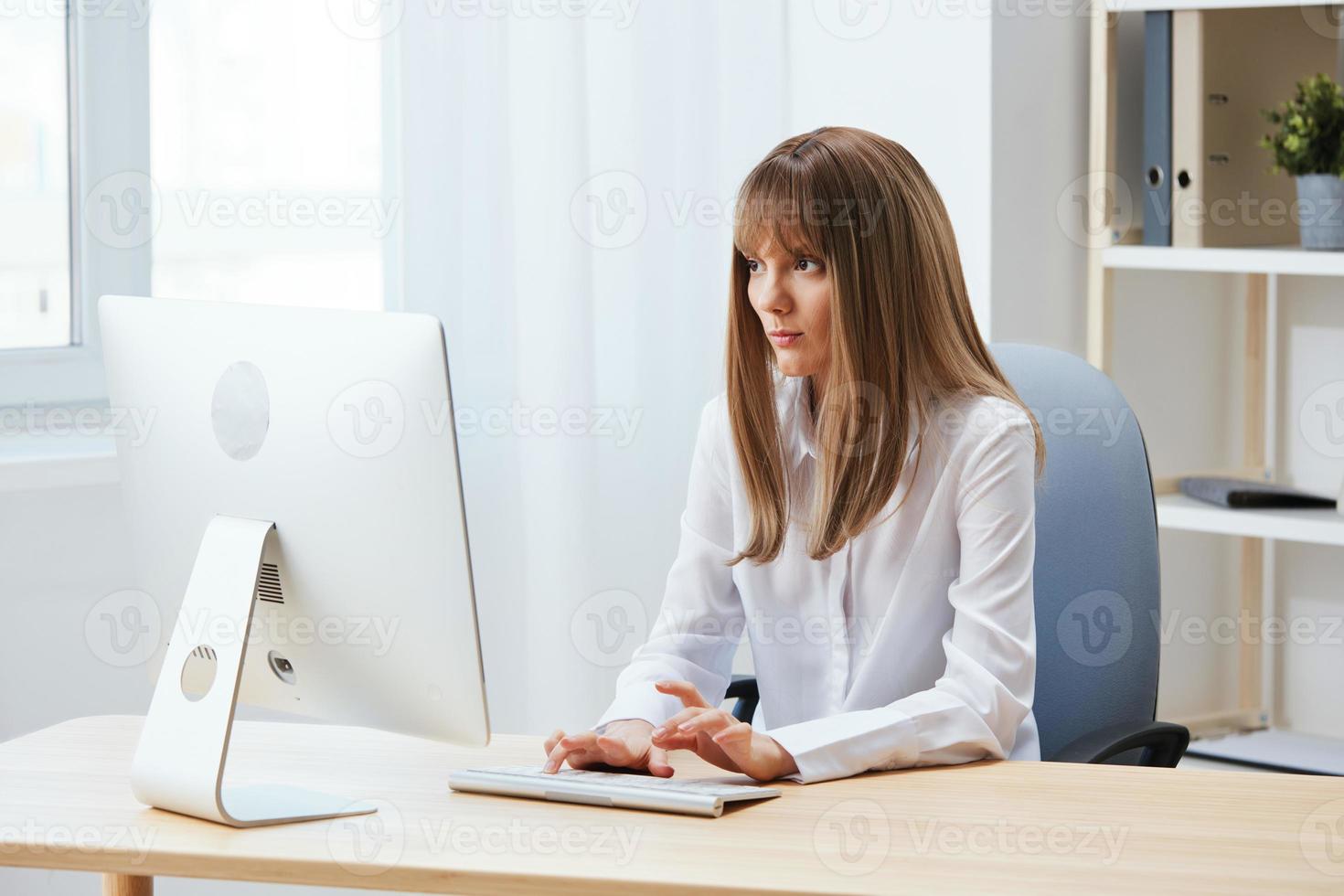 Focused adorable blonde businesswoman worker freelancer look at screen thinking of problem solution in light modern office. Employee work on computer online pondering or making decision. Copy space photo