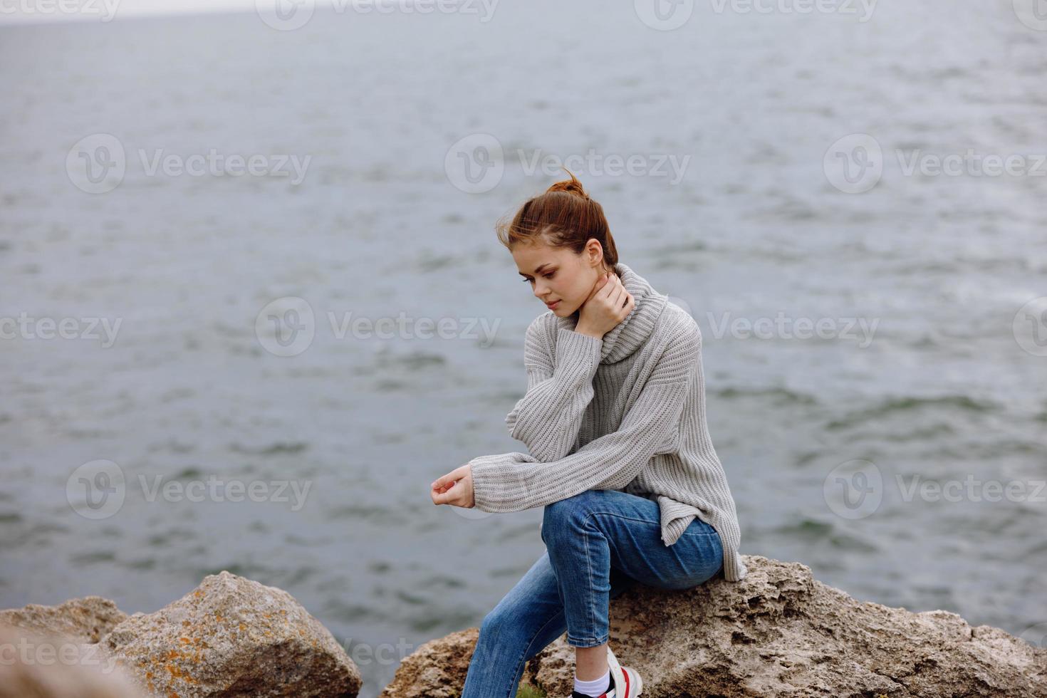 portrait of a woman sweaters cloudy sea admiring nature Relaxation concept photo