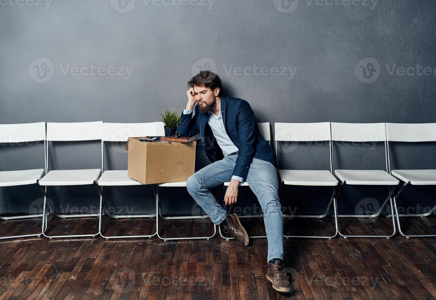 Man sits on a chair box with things dismissing discontent depression photo