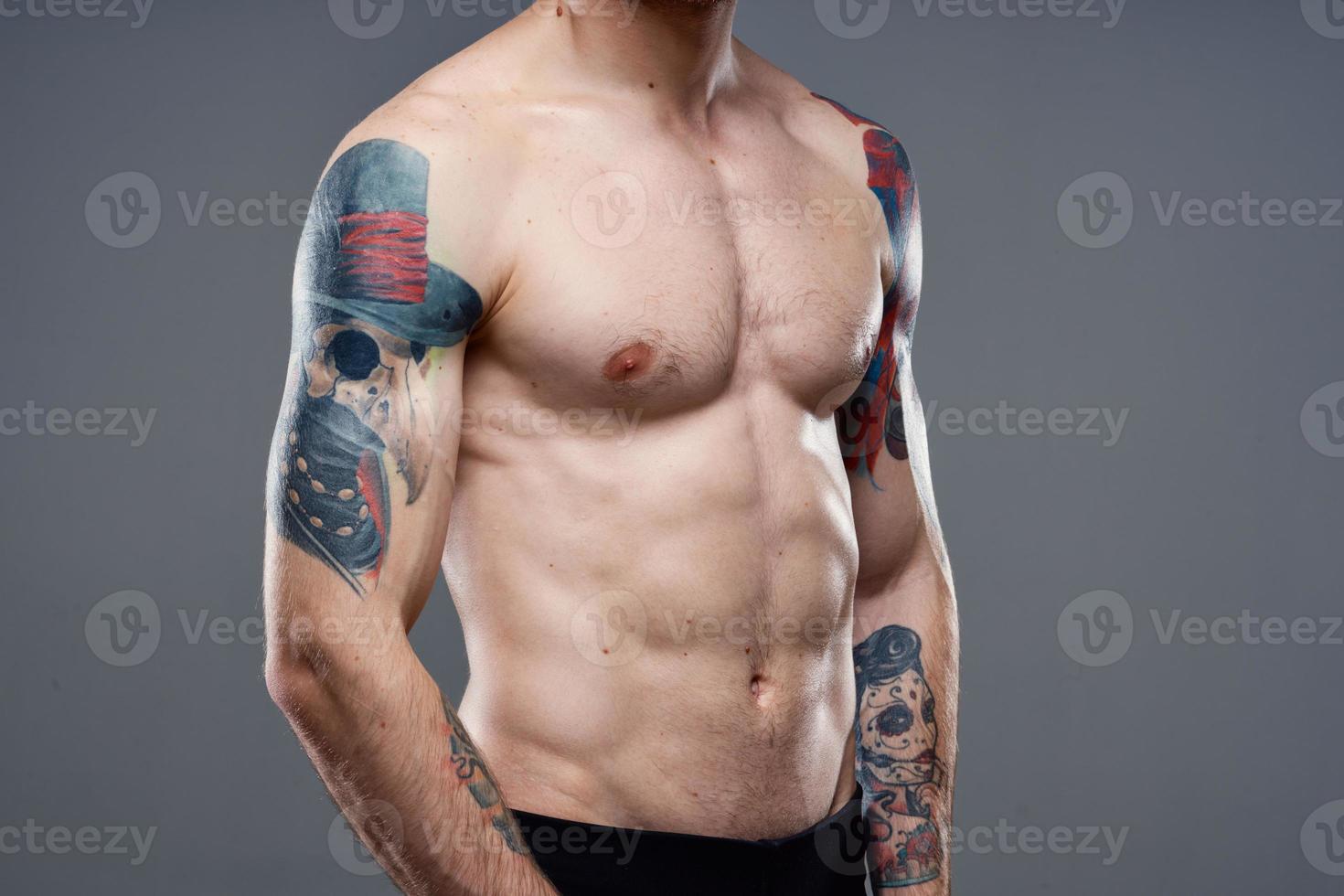 man with tattoos on his arms naked torso pumping up abs workout photo