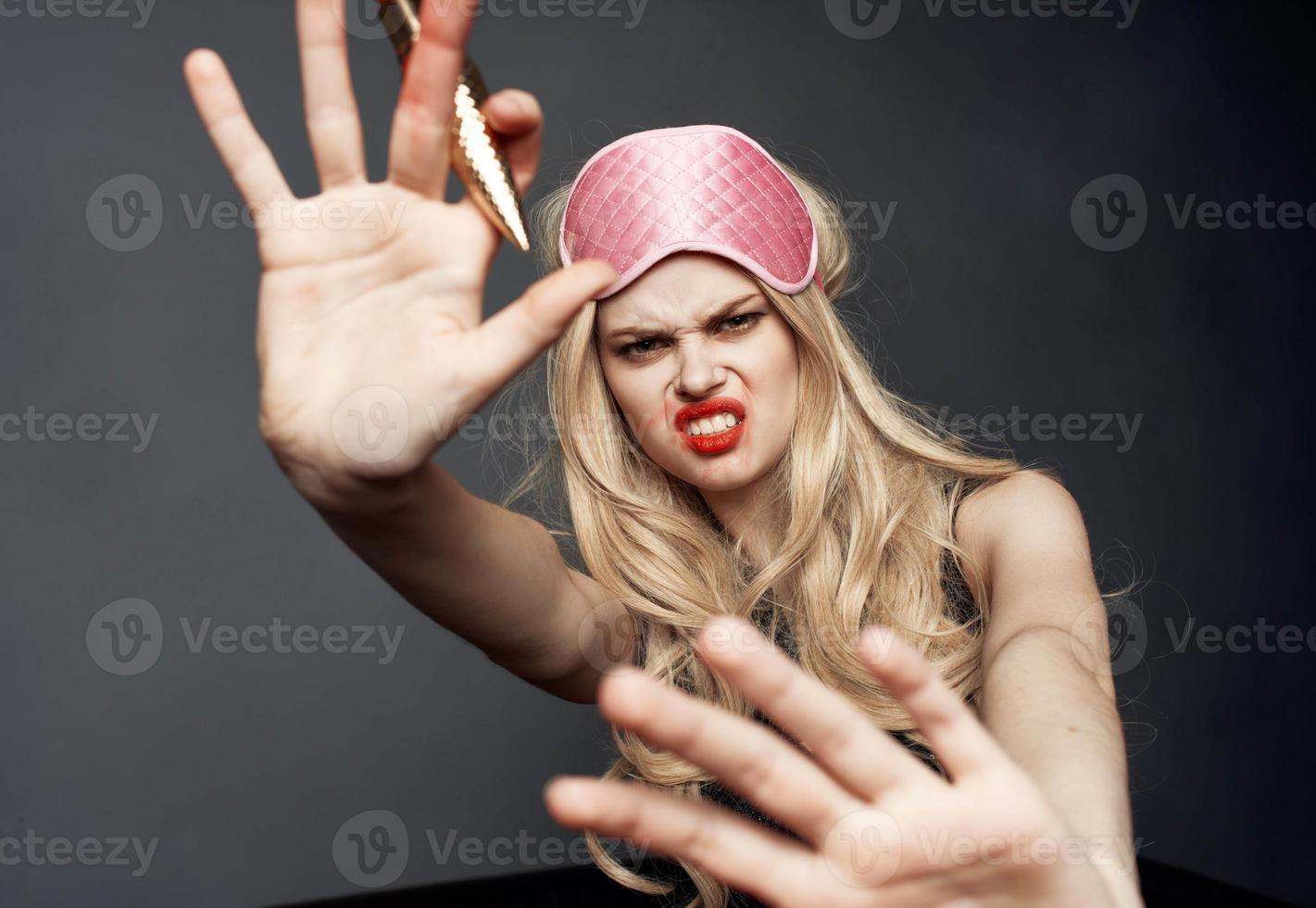 drunk woman with bright makeup gesturing with her hands palm gray background photo
