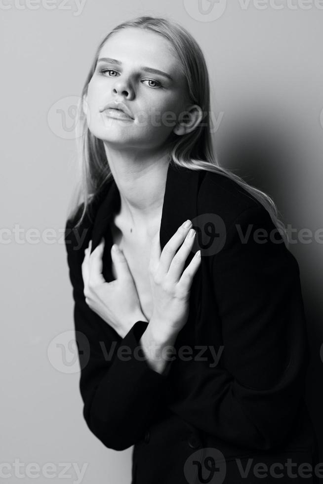 un elegante profesional modelo cruces su brazos en su cofre y sostiene un chaqueta mientras posando en el estudio. de moda elegante foto. concepto para ropa marcas foto