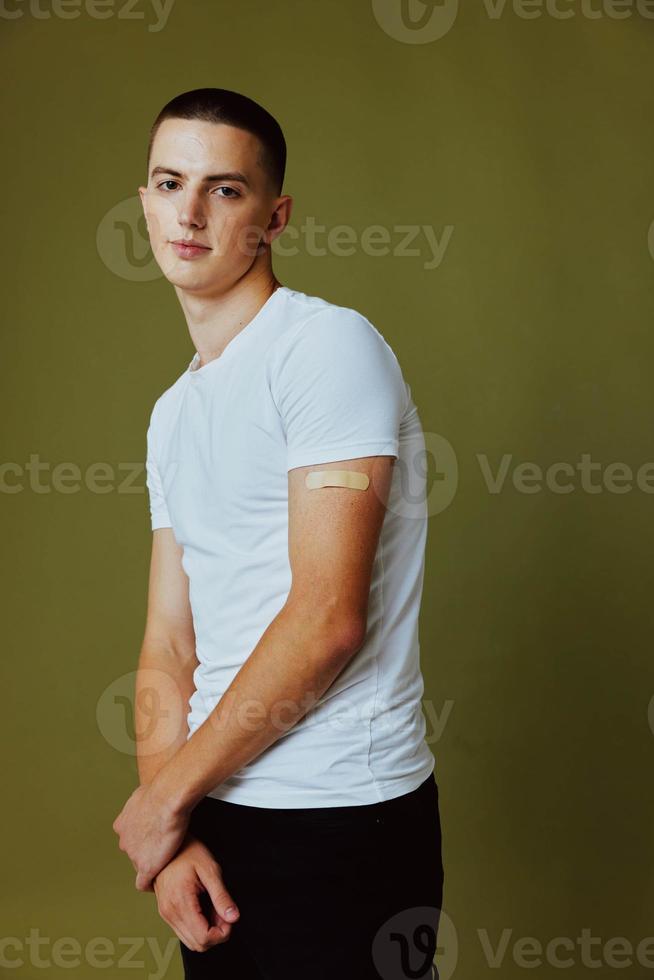 handsome man in white t-shirt with adhesive plaster on his arm immunity protection vaccine passport photo