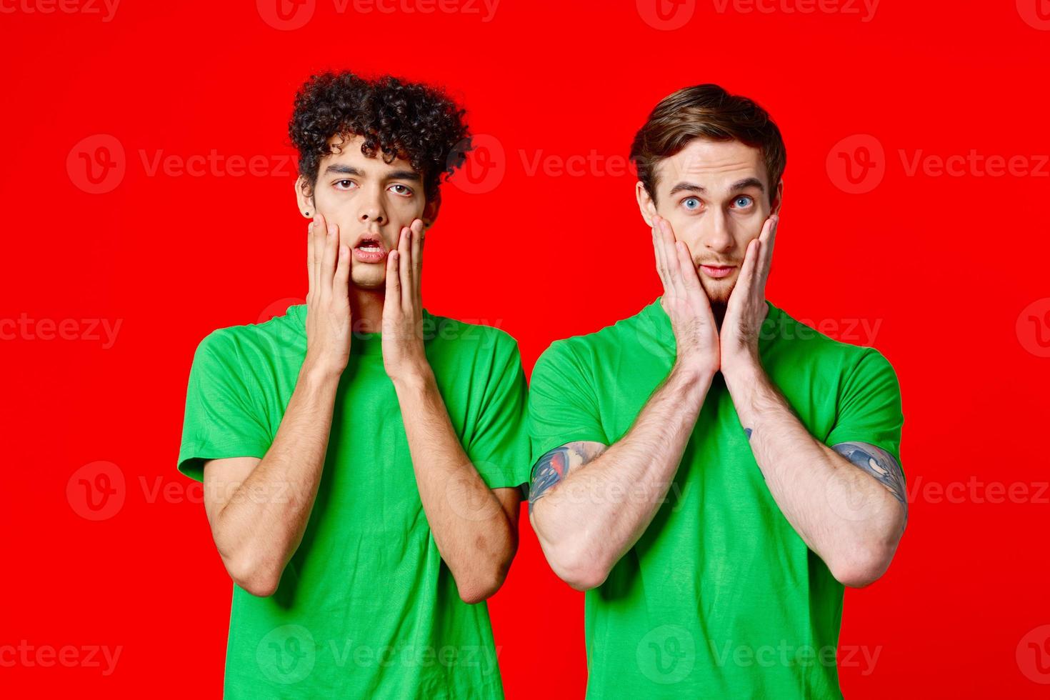 Cheerful friends in green t-shirts hold on to the face of emotion photo
