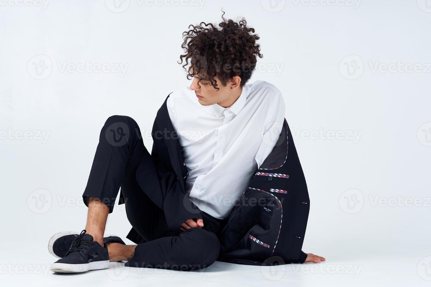 guy sitting on the floor curly hair suit modern style photo