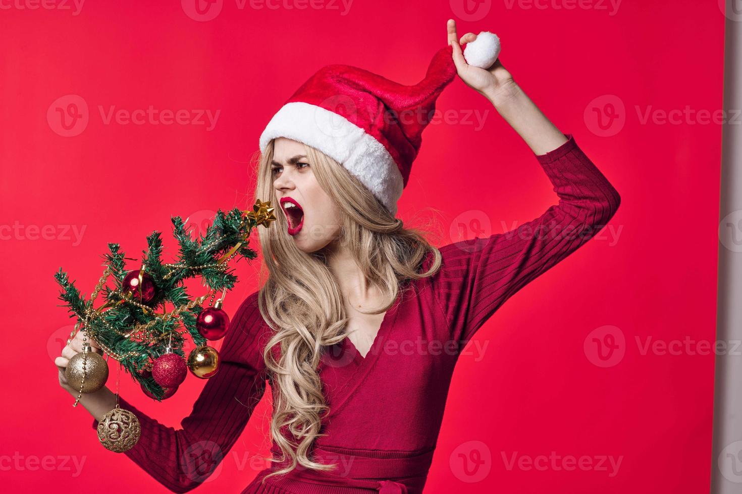 woman in red dress christmas tree toys holiday pink background photo