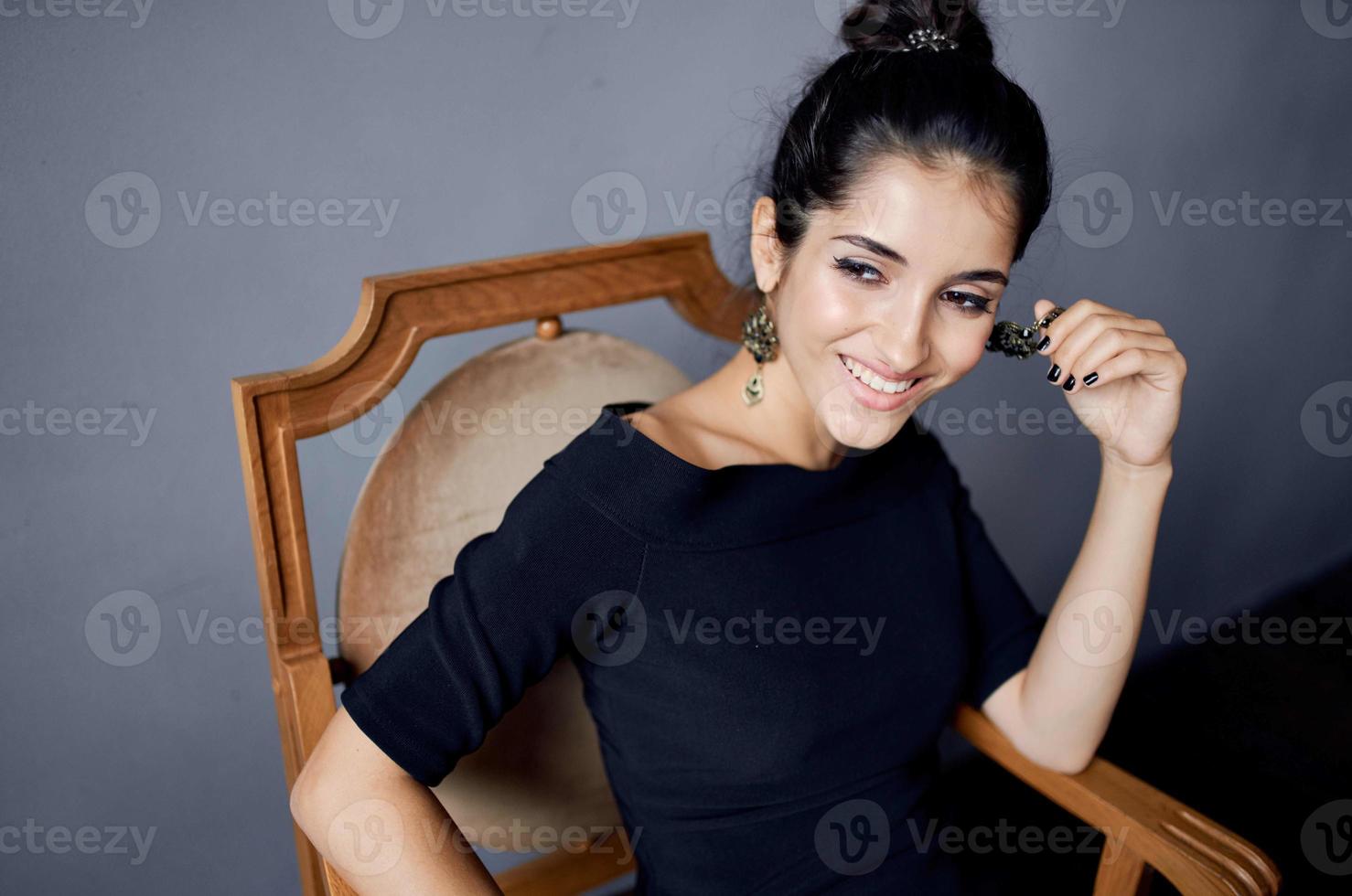beautiful woman in a black dress near the chair luxury fashion lifestyle studio photo
