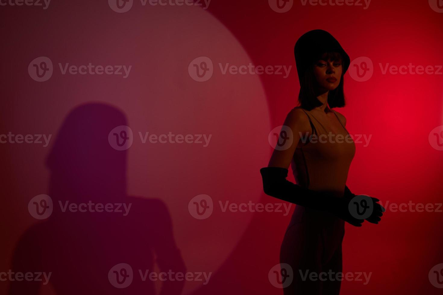 woman on stage spotlight shadows posing red neon photo