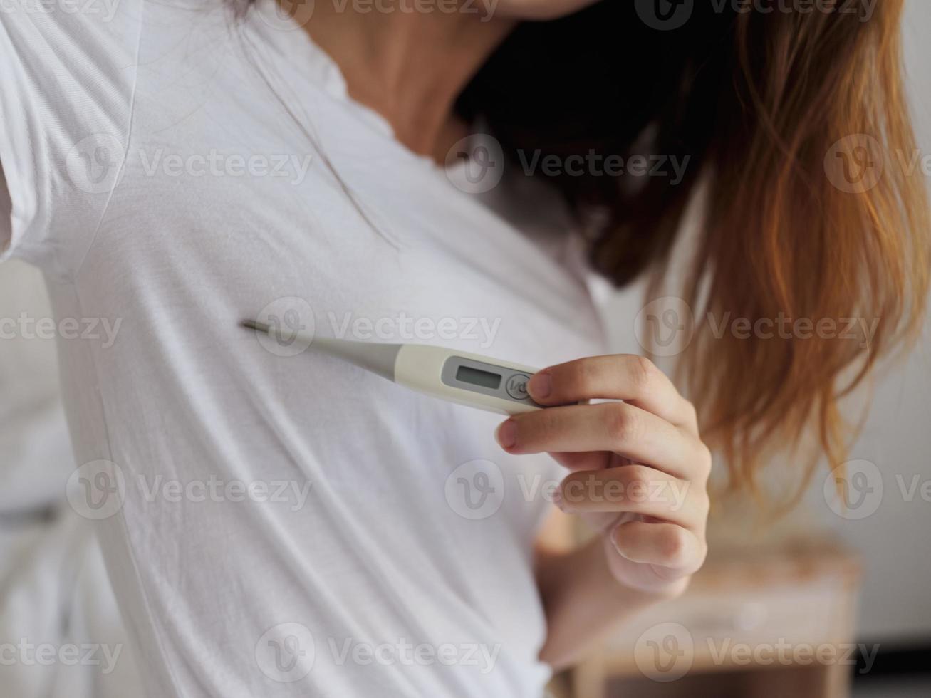 joyful woman hands checking armpit temperature photo