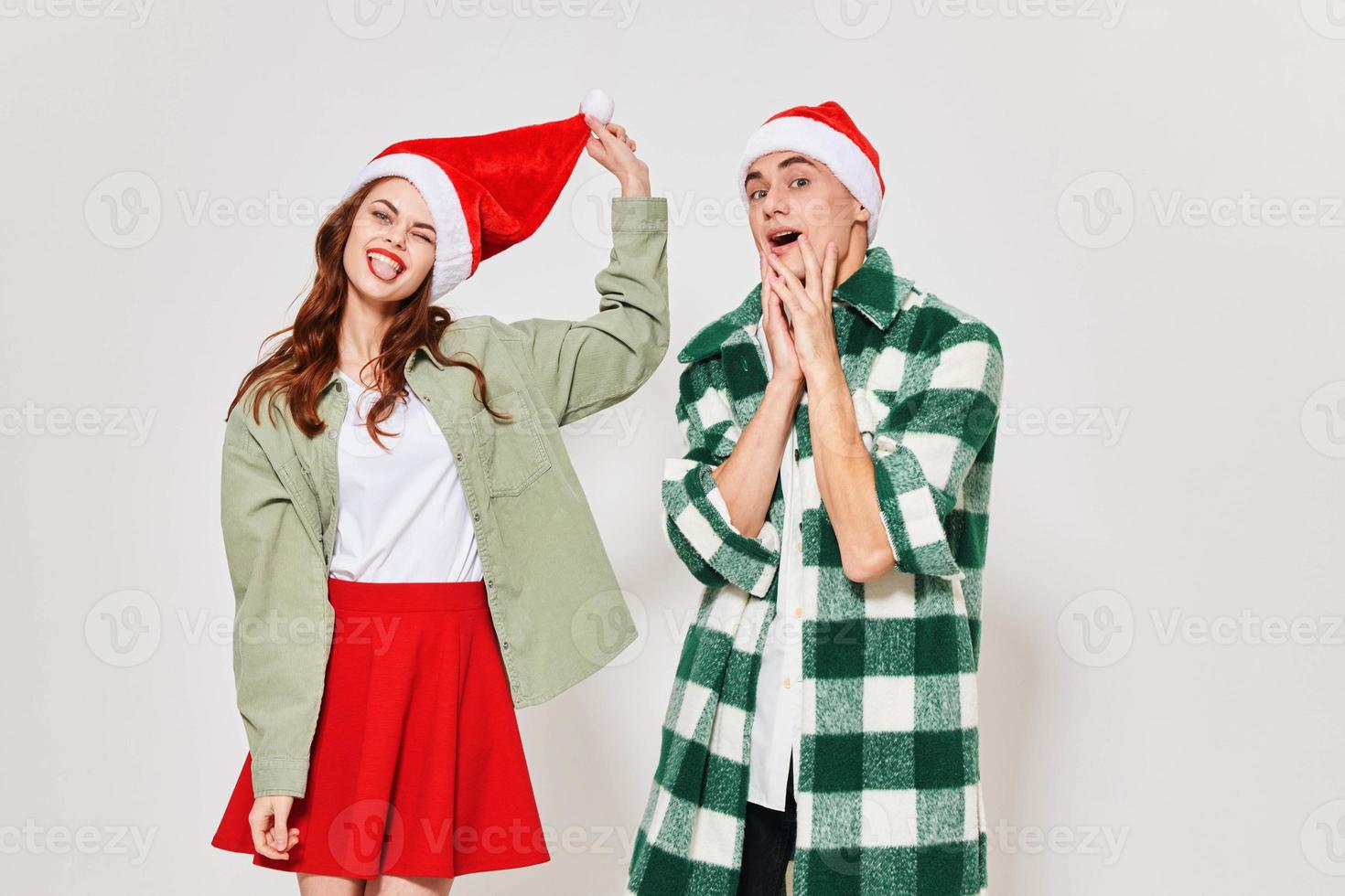 A guy in a plaid shirt and a woman in a Christmas hat on a light background photo