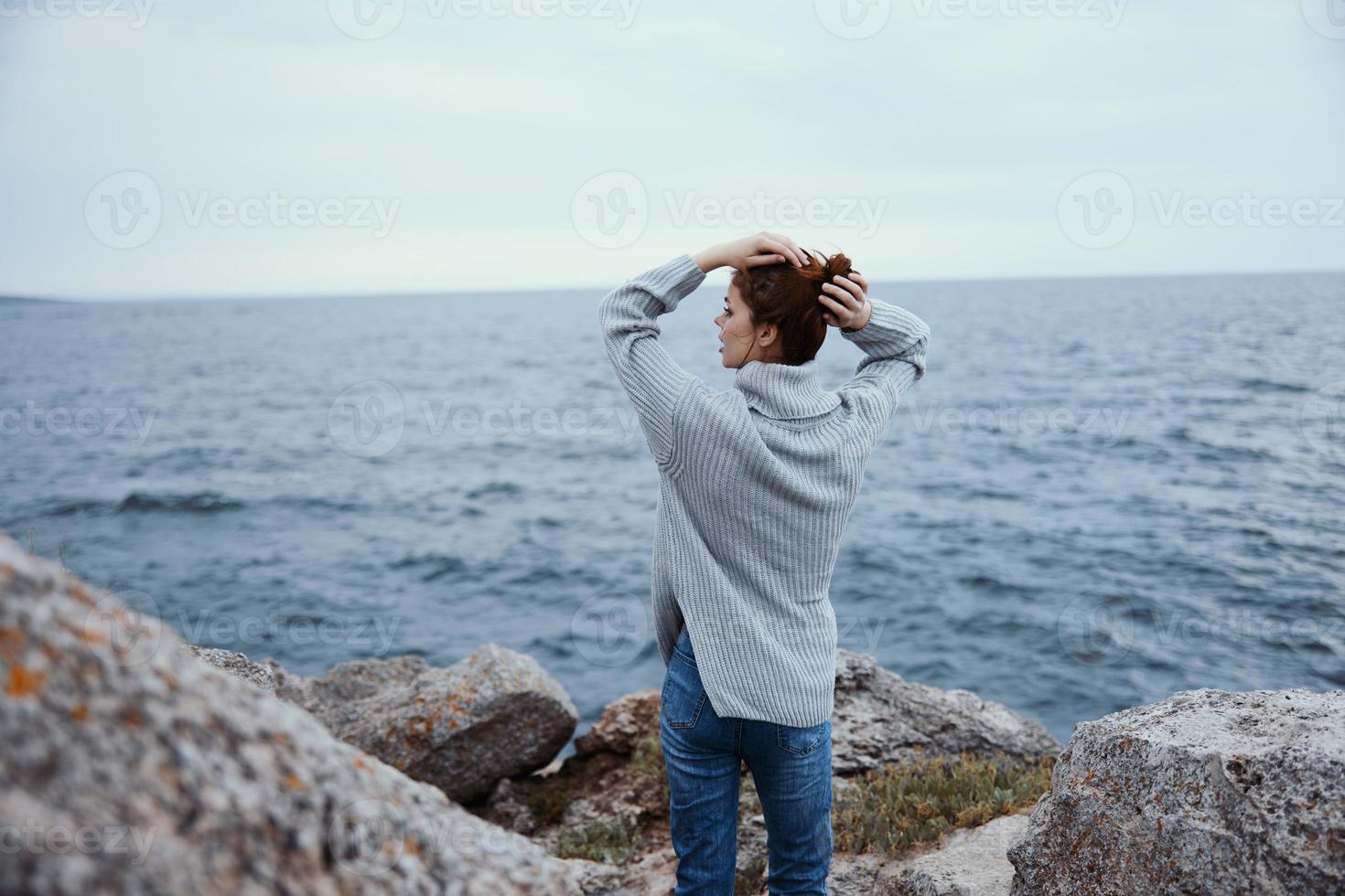 portrait of a woman sweaters cloudy sea admiring nature unaltered back view photo
