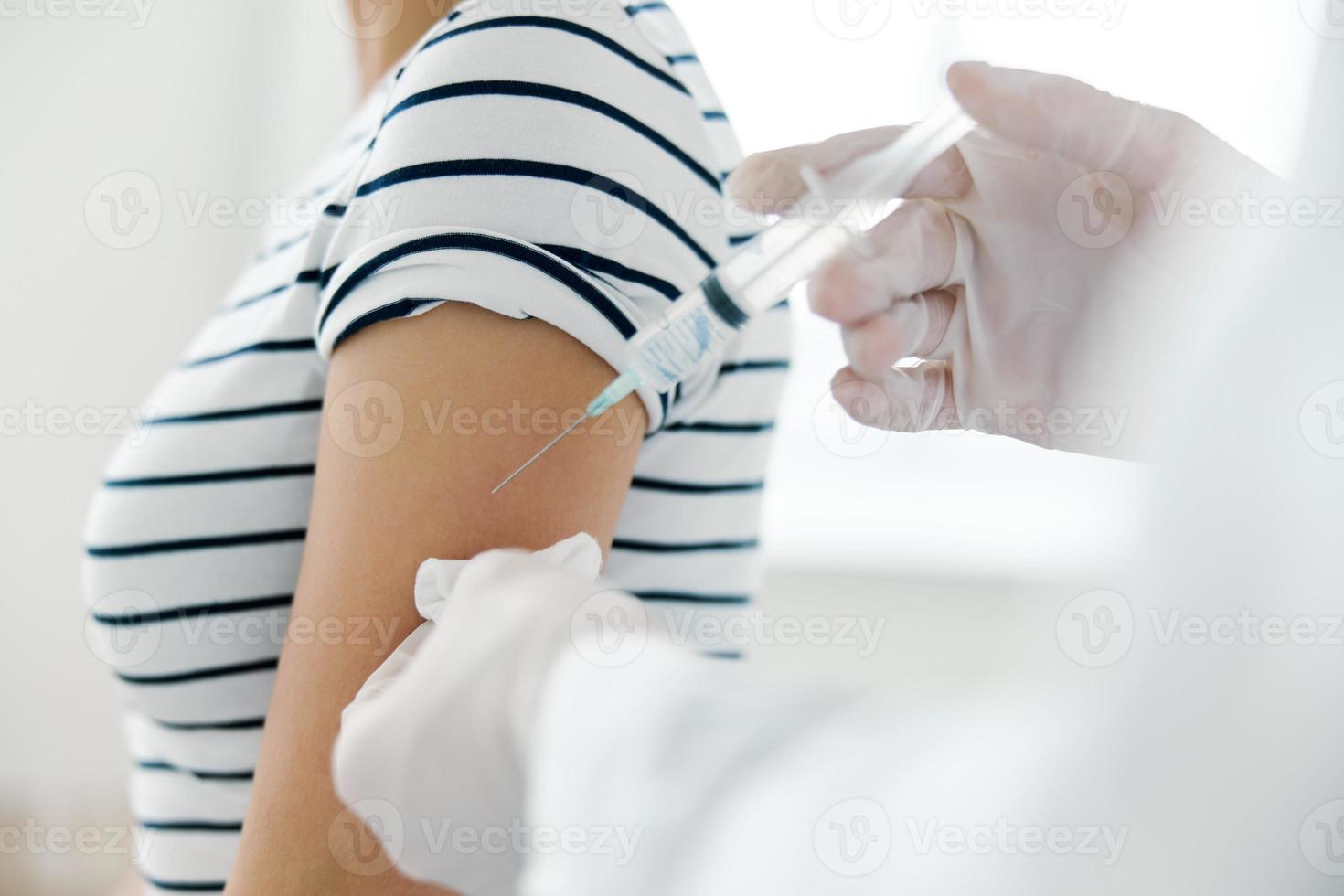 Injection of vaccine into shoulder in hospital close-up photo