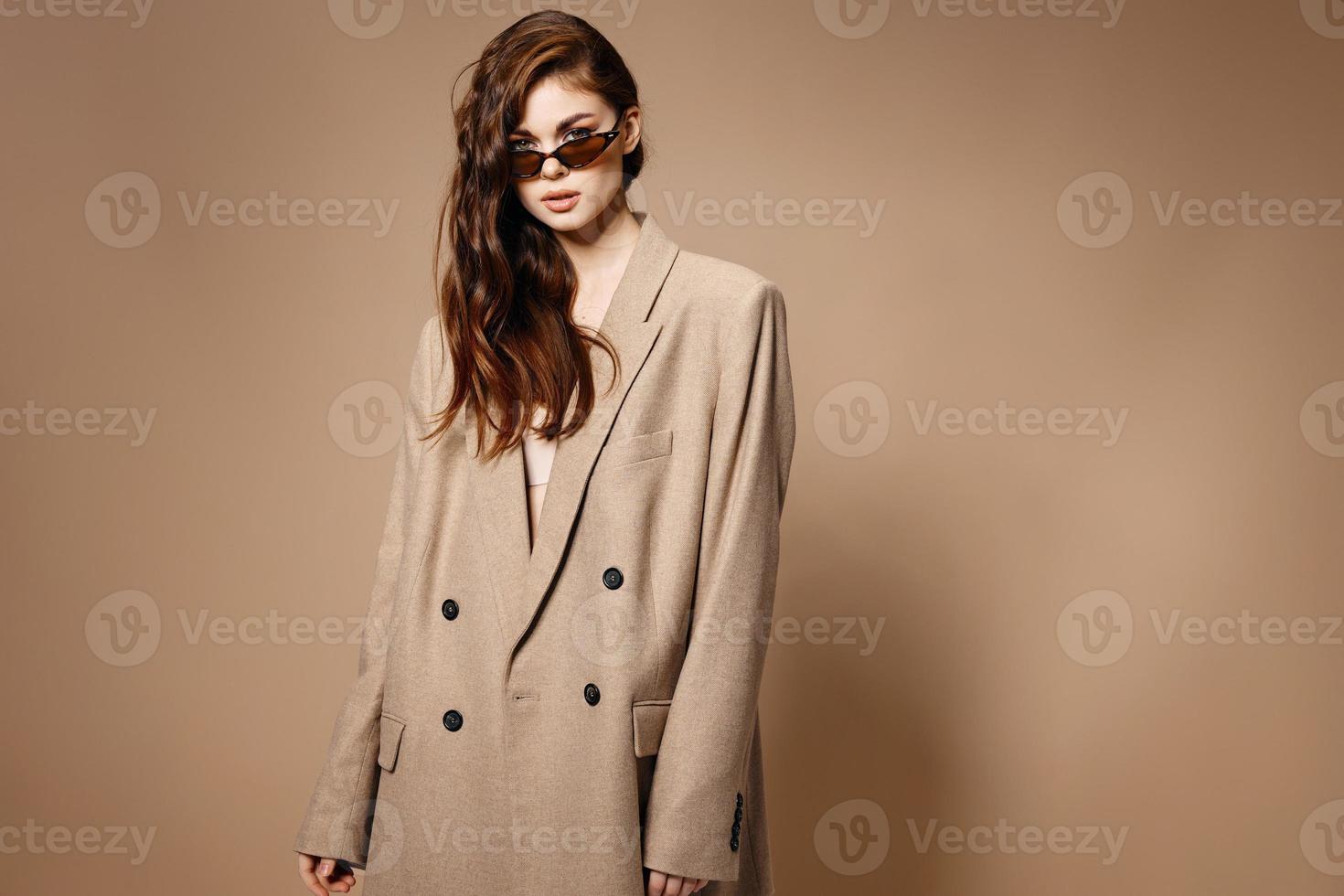 stylish brunette woman in coat on beige background Copy Space photo