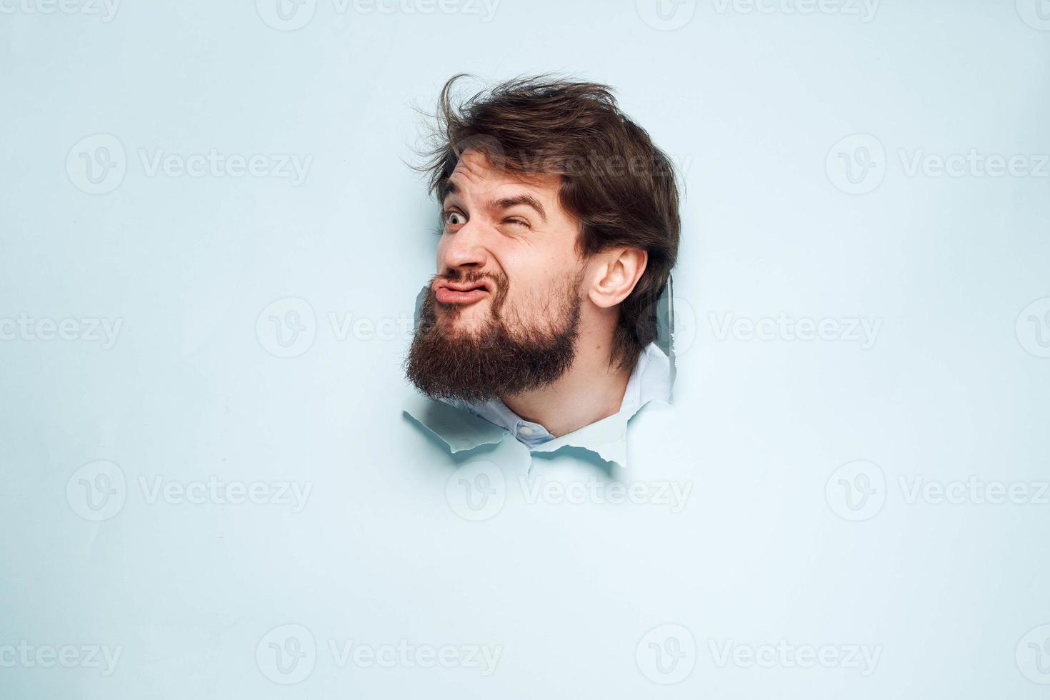 A disgruntled man looks out from behind the wall of the office manager's job photo