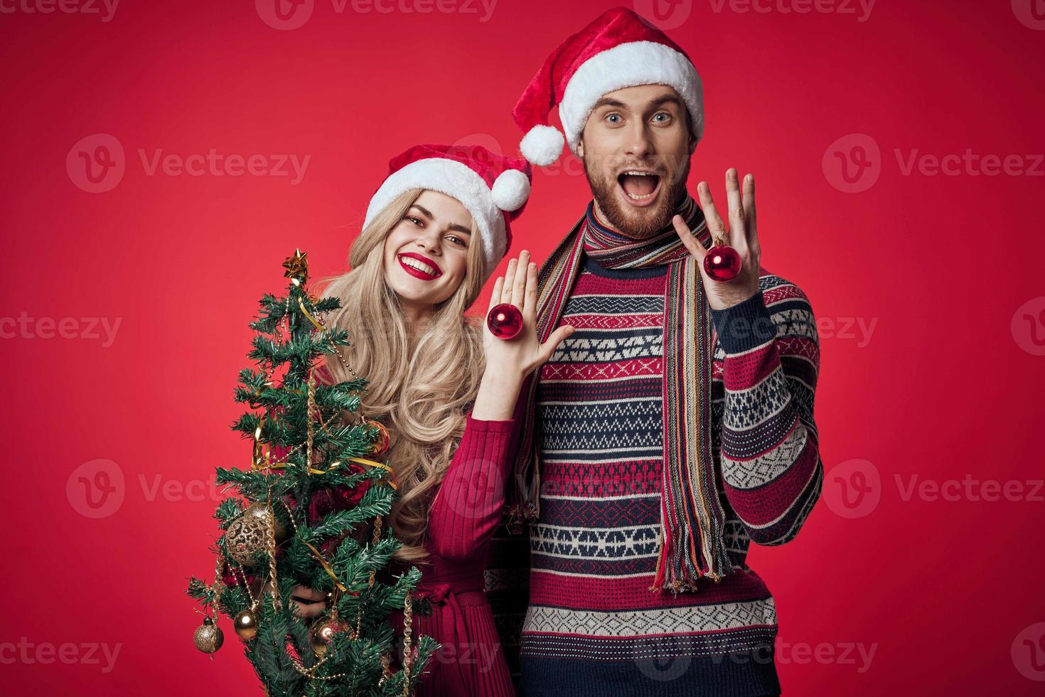 man and woman are standing next to New Years holiday Christmas gifts photo