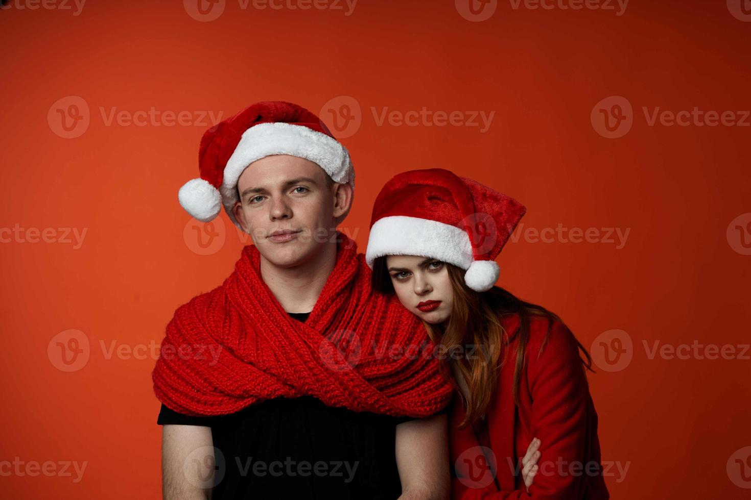 family in santa hats fun new year holiday red background photo