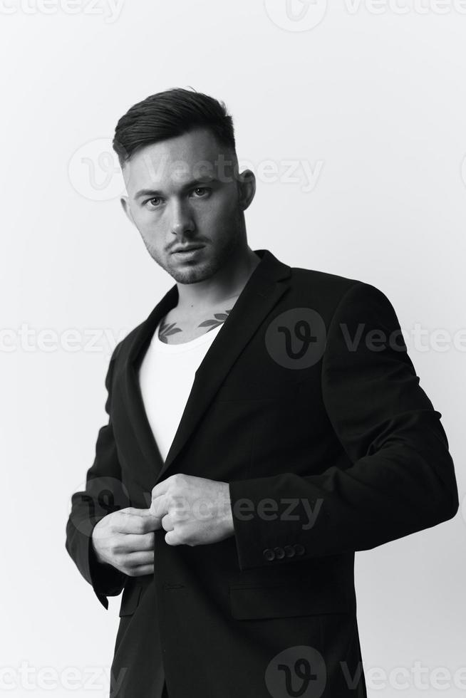 Modelling snapshots. Serious self-confident attractive handsome man in classic suit wear jacket posing isolated in white studio background. Black and White concept. Fashion offer. Copy space photo